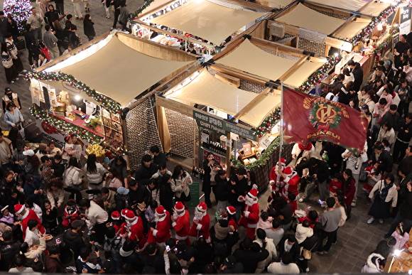 관광객들이 ‘크리스마스 빌리지 부산 2025’에서 행사를 즐기고 있다. [사진=푸드트래블]