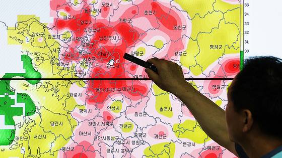 폭염이 기승을 부린 지난 7월 28일 오후 경기도 수원시 권선구 수도권기상청에서 예보관이 수도권 폭염특보상황과 최고 기온을 보여주고 있다. 우상조 기자