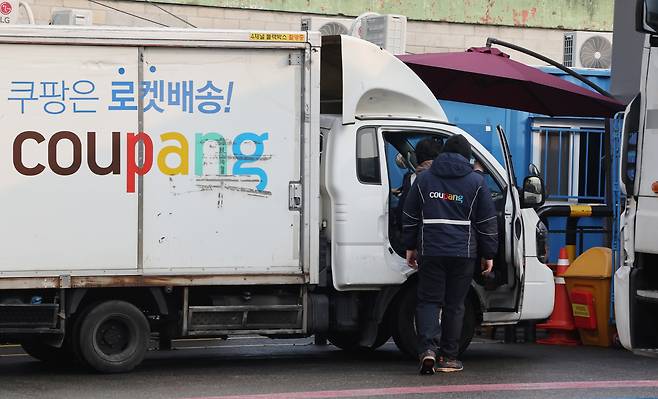 Coupang workers are seen next to a delivery truck at the company's logistics center in Seoul on Dec. 29. [YONHAP]