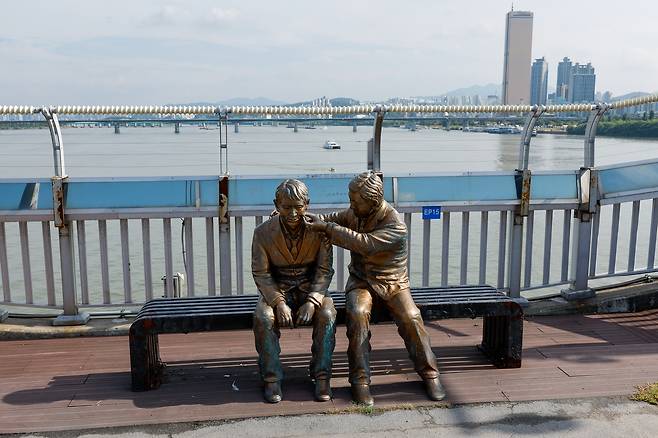 A statue of a person comforting another, meant to alert the public to suicide prevention, is seen on Mapo Bridge in Seoul on Sept. 25. [NEWS1]