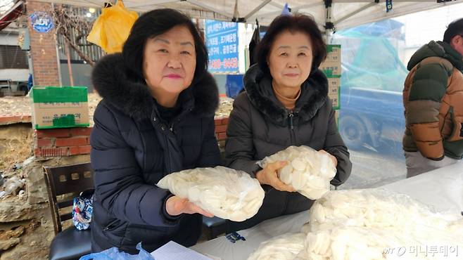 29일 오후 서울 송파구 거여역 3번 출구 인근 사회적협동조합 '기부천사'가 연 연말 자선바자회 현장. 김순이씨와 홍신기씨가 판매 중인 떡국떡을 들어 보이고 있다. /사진=김미루 기자.