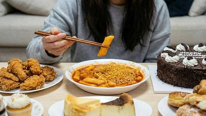 스트레스를 음식으로 풀 때 폭식으로 이어질 수 있어 주의가 필요하다 | 출처: Gemini 생성