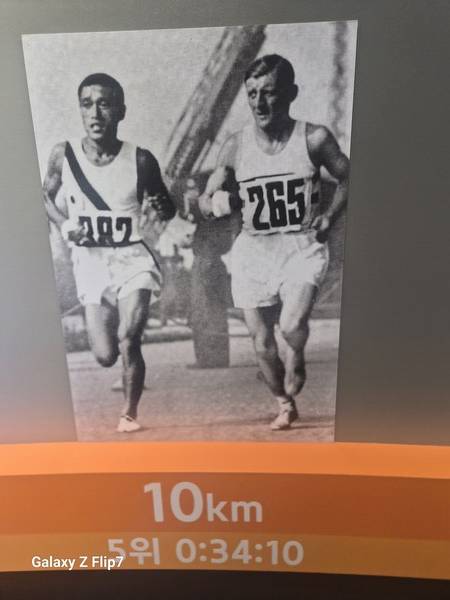 손기정이 영국의 하퍼와 선두 경쟁을 벌이며 출발 10km 지점을 통과하고 있는 사진.&nbsp;