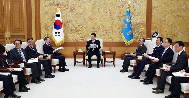 President Lee Jae Myung (center) holds a meeting with his aides over tea in the main hall of the Cheong Wa Dae presidential compound on Monday. (Yonhap)