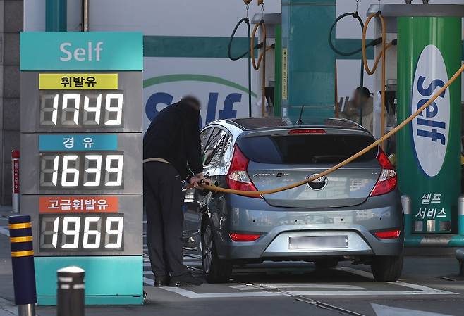 A driver fills their car with gas at a gas station in Seoul on Dec. 31. [NEWS1]