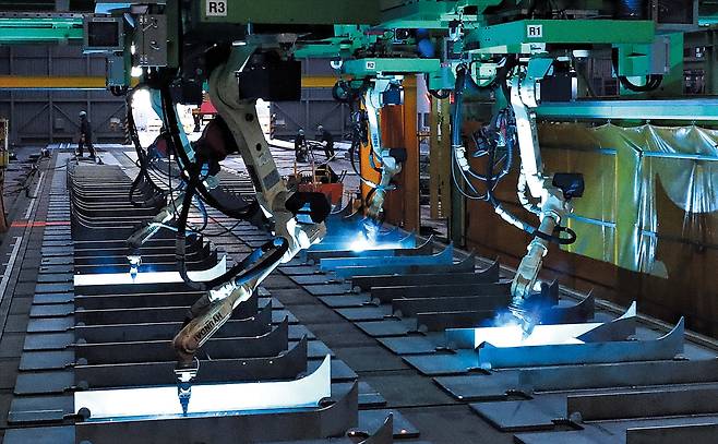 용접 작업하는 로봇들  지난 12월 18일 울산 남구 황성동 HD현대중공업 용연 공장에서 로봇 4대가 선박 구조물을 용접하고 있다. 기존엔 6명이 한 달간 500t 물량을 용접했지만 로봇이 투입된 지금은 월간 900t의 물량을 용접할 수 있다. HD현대는 로봇의 용접 범위를 더 확대하기 위해 AI 학습용 빅데이터를 축적하고 있다./김동환 기자