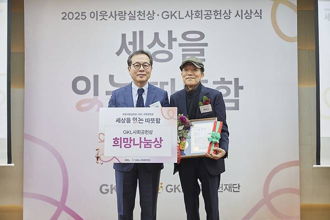 배영근 씨(오른쪽)가 2025년 12월 12일 서울 프레지던트호텔에서 열린 ‘이웃사랑실천상·GKL사회공헌상’ 시상식에서 희망나눔상을 수상한 뒤 기념촬영을 하고 있다. 왼쪽부터 이재경 GKL사회공헌재단 이사장, 배영근 씨.