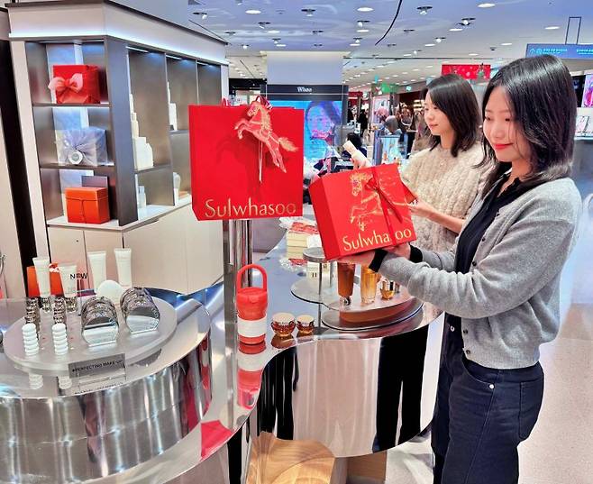 백화점 업계가 2일부터 새해 첫 정기세일에 일제히 들어가는 가운데 서울 소공동 롯데백화점 본점 지하 1층 설화수 매장에서 직원들이 붉은 말의 해 프로모션 단독 기프트 세트를 소개하고 있다. 롯데백화점 제공