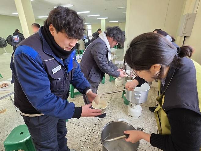 한국지엠 세종부품물류센터 해고 노동자 최현욱(36)씨가 1일 ‘집단해고 철회’를 촉구하는 점거 농성장에서 새해맞이 떡만둣국을 배식받고 있다. 최예린 기자