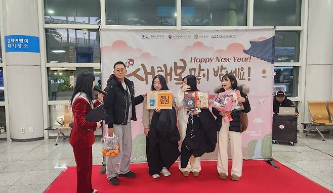 제주도관광협회 관계자들이 새해 첫날 제주국제공항에서 방문객들에게 감귤과 기념품을 전달하고 있다. (제주도관광협회 제공)