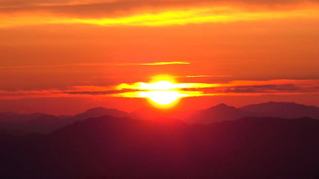 The first sun of the year rises in red hues over the eastern sky, as seen from the summit of Gamak mountain in Geochang county, South Gyeongsang Province on Thursday. (Geochang county, Yonhap)