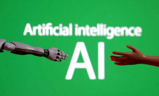 Words reading ″Artificial intelligence AI,″ and miniature robot and toy hands are pictured in this illustration made on Dec. 14, 2023. [REUTERS/YONHAP]