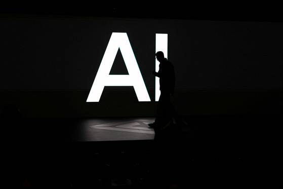 A screen reads 'AI' in reference to artificial intelligence as attendees gather during Rivian's first Autonomy and AI Day, showcasing developments in self-driving technology, in Palo Alto, California, on Dec. 11. [REUTERS/YONHAP]