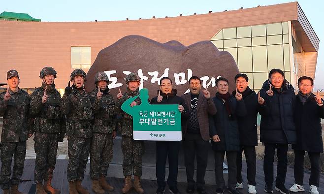 Hana Bank CEO Lee Ho-seoung, sixth from left, and employees pose for a photo with the commander of the Army’s 1st Infantry Division, fifth from left, and military officials during a visit to the Dora Observatory at the 1st Infantry Division base in Paju, Gyeonggi, on Jan. 1. [HANA BANK]
