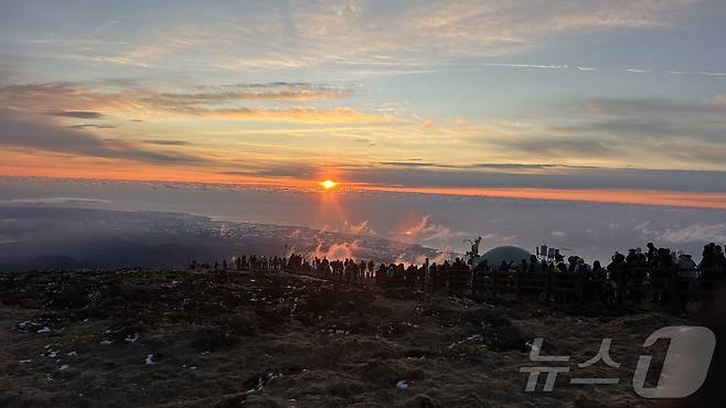 2026년 새해 첫날인 1일 제주 한라산 정상인 백록담에 오른 탐방객들이 구름 사이로 뜨는 해를 바라보고 있다.(한라산국립공원관리소 제공. 재판매 및 DB 금지). 2026.1.1/뉴스1 ⓒ News1 강승남 기자