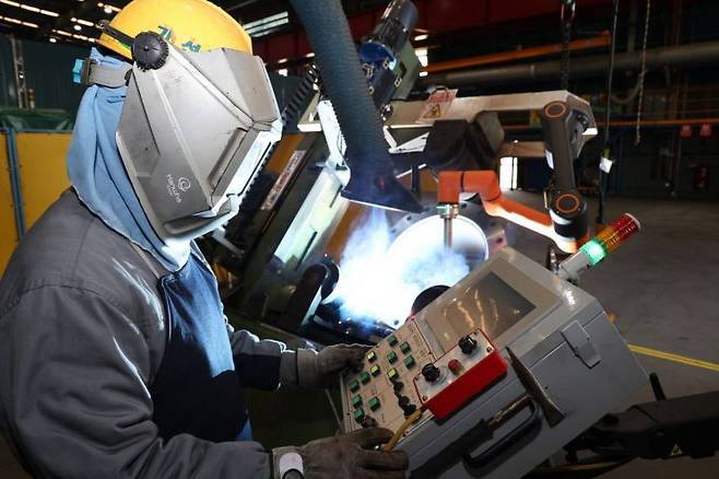 경남 거제시 한화오션 조선소에서 용접공이 배관 용접용 협동로봇을 활용해 작업하고 있다. 한화오션