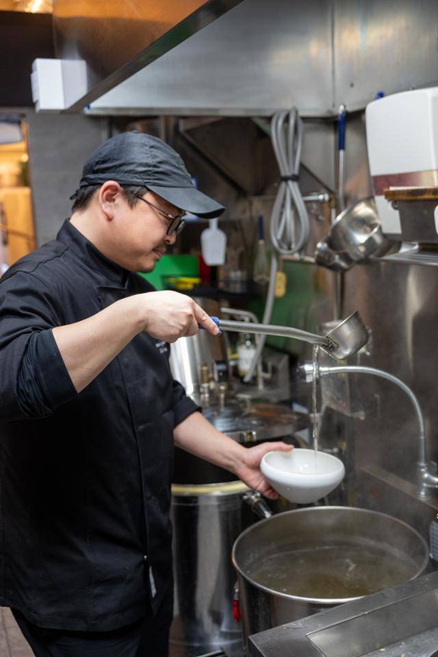 신민섭 셰프가 주방에서 그릇에 돼지국밥을 담아내고 있다
