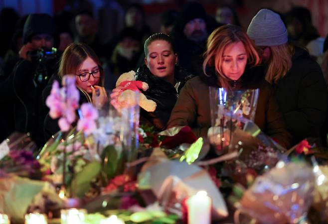 스위스 클럽 화재로 숨진 희생자들을 추모하기 위해 꽃다발을 놓는 시민들. [로이터 연합뉴스]