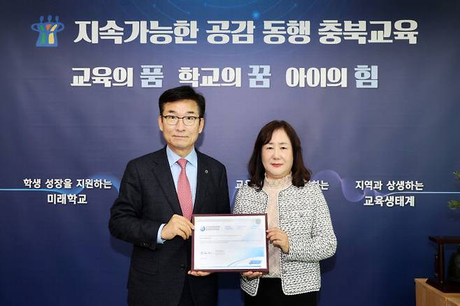 지난해 12월 31일 월드스쿨 인증 기념촬영. 윤건영 교육감, 정관숙 단재고교장이 월드스쿨 인증서한과 인증서를 들고 기념촬영하고 있다.(사진=충북교육청)