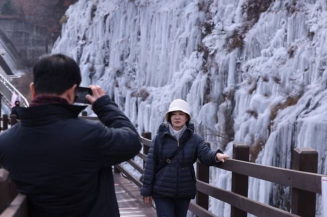 ▲ 절기상 소한(小寒)을 하루 앞둔 4일 오전 대구 달성군 옥연지 송해공원을 찾은 관광객들이 빙벽을 배경으로 기념촬영을 하고 있다.김영환 기자yhk@kyongbuk.com