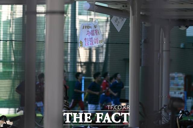 일본 오사카에 위치한 오사카조선중고급학교에 '조청원의 힘으로 주륜장을 늘 알뜰히 꾸리자'라고 쓰여진 한글 뒤로 어린이들이 축구를 하고 있다. /오사카=서예원 기자