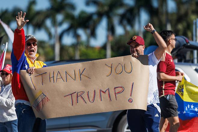 3일 미국 플로리다주 마러라고에서 베네수엘라계 이민자들이 도널드 트럼프 대통령의 군사 작전을 지지하는 플래카드를 들고 있다. /EPA 연합뉴스
