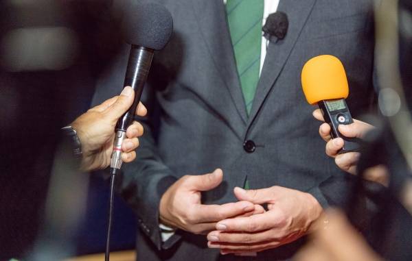▲정장을 입은 사람의 상반신 앞에 두 개의 취재용 마이크를 든 손이 보이는 모습으로 연출된 이미지. 사진=Getty Images Bank