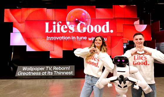 LG전자가 미국 라스베이거스에서 열리는 가전·정보기술(IT) 박람회 ‘CES 2026’ 전시관 입구에 초슬림·초밀착 무선 월페이퍼 TV ‘LG 올레드 에보 AI W6’ 38대를 천장에 매단 초대형 오브제로 관람객들을 맞이한다. 홈 로봇 'LG 클로이드'와 모델들이 초대형 오브제 앞에서 다양한 포즈를 취하고 있다. 사진 LG전자