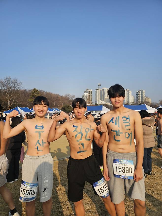 Cha Sung-yoon (center) poses with two friends ahead of the start of the marathon. Together, the messages on the trio read "three idiots from Jangan High School in Busan." (Choi Jae-hee/The Korea Herald)