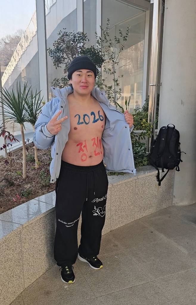 Lee Dong-ho poses with the Korean word “jeongjin,” meaning "moving forward," painted across his belly. (Choi Jae-hee/The Korea Herald)