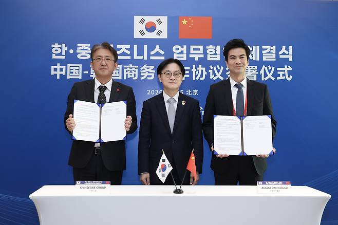 From left: Park Jong-hoon, head of strategic planning at Shinsegae’s E-mart division, Korea’s Industry Minister Kim Jung-kwan, and James Dong, president of Alibaba International Digital Commerce, pose for a photo during a signing ceremony in Beijing on Monday. (Shinsegae)