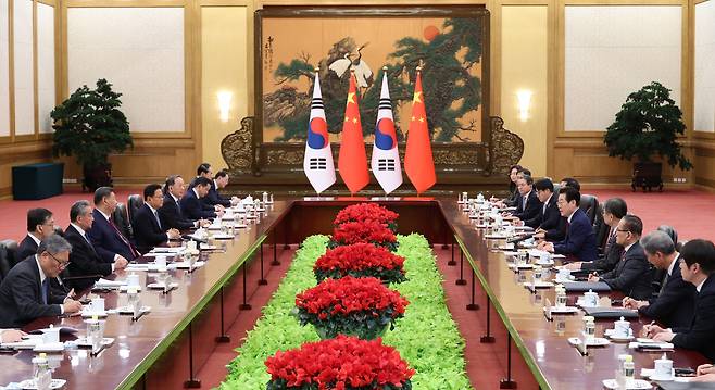 President Lee Jae Myung (left) and Chinese President Xi Jinping hold a summit at the Great Hall of the People in Beijing on Monday. (Yonhap)