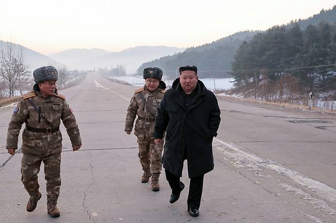 Kim Jong-un, right, general secretary of the Workers’ Party of Korea, walks with officers in a photo released by the state-run Rodong Sinmun on Jan. 5. [RODONG SINMUN]