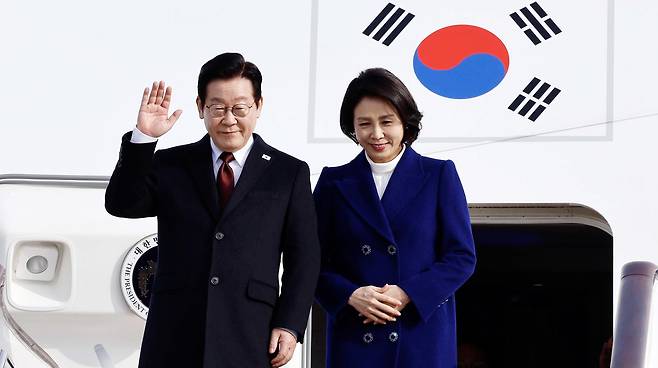 President Lee Jae Myung, left, and first lady Kim Hea Kyung arrive at Beijing Capital International Airport in Beijing on Jan. 4. [JOINT PRESS CORPS]