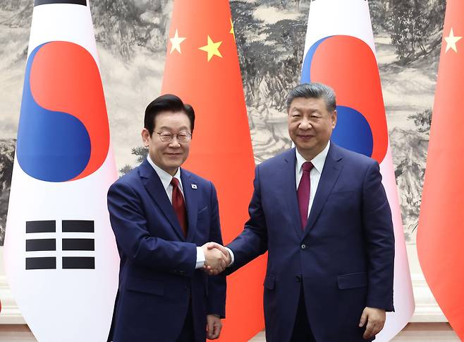 President Lee Jae Myung, left, shakes hands with Chinese President Xi Jinping during their bilateral summit at the Great Hall of the People in Beijing on Jan. 5. [JOINT PRESS CORPS]