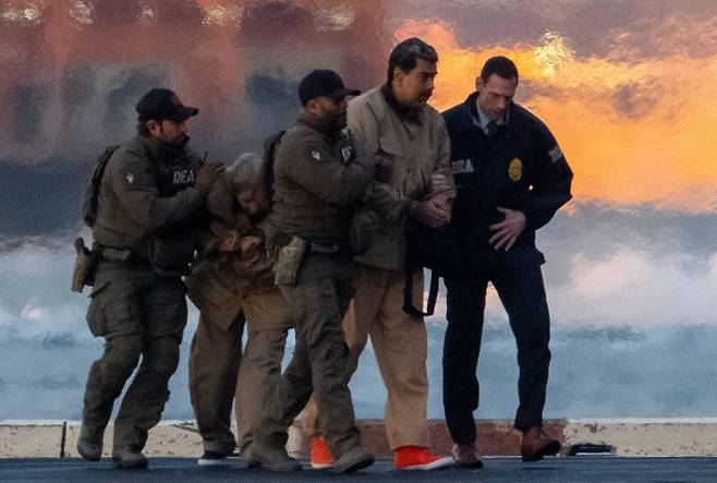 지난 5일 베네수엘라 대통령 니콜라스 마두로와 그의 부인 실리아 플로레스가 첫 심리에 출석하기 위해 맨해튼 다운타운 헬리포트에서 연방법원으로 향하고 있다. 로이터 연합뉴스