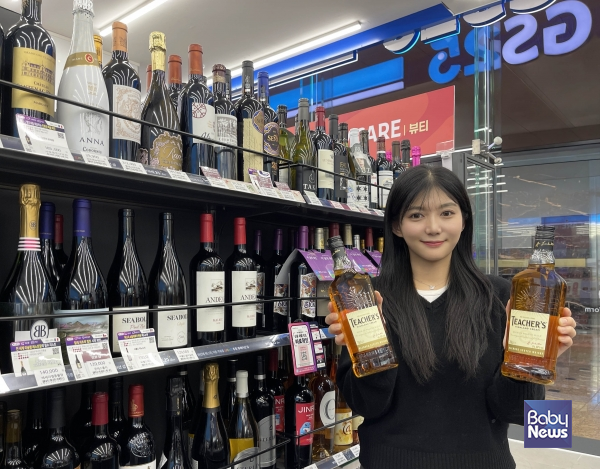 모델이 GS25에서 선보인 1만원대 가성비 위스키 '티처스' 상품을 들고 있다. ⓒGS25