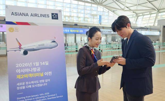 아시아나항공이 14일부터 인천국제공항 제2여객터미널로 이전을 앞둔 가운데 한 직원이 승객에게 터미널 이전을 안내하고 있다. 아시아나항공 제공
