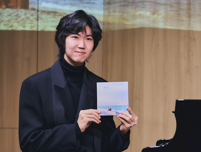 Pianist Kim Song-hyeon poses for a photo with his second album "Timescape" on Tuesday in Seoul.  (Music&Art Company)