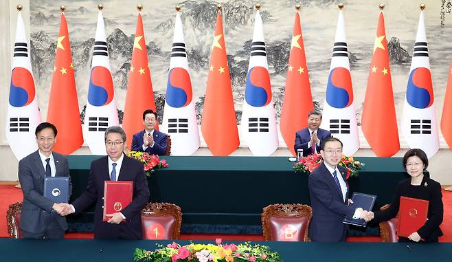 President Lee Jae Myung, back left, and Chinese President Xi Jinping, back right, clap during the signing ceremony for a memorandum of understanding at the Great Hall of the People in Beijing on Jan. 5. [JOINT PRESS CORPS]
