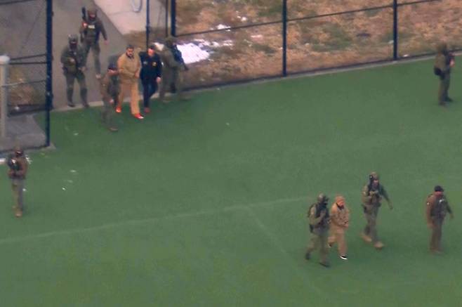 [뉴욕=AP/뉴시스] 수갑을 찬 니콜라스 마두로 베네수엘라 대통령 부부가 5일(현지 시간) 미국 뉴욕에서 맨해튼 연방법원으로 향하는 헬리콥터에 탑승하기 위해 호송되고 있다. 2026.01.06.