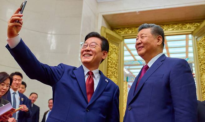 중국을 국빈 방문 중인 이재명 대통령이 5일(현지 시간) 베이징 인민대회당에서 열린 공식만찬을 마친 뒤 경주 정상회담에서 시진핑 국가주석에게 선물 받은 샤오미폰으로 시 주석과 셀카를 찍고 있다. 뉴시스