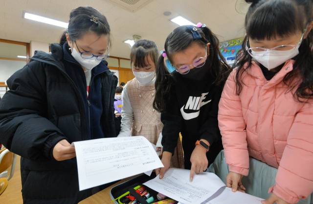 기사와 무관한 사진. 경기 수원시 영통구 신영초등학교에서 열린 방학식에서 2학년 1반 학생들이 생활 통지표를 보고 있다. 공동취재
