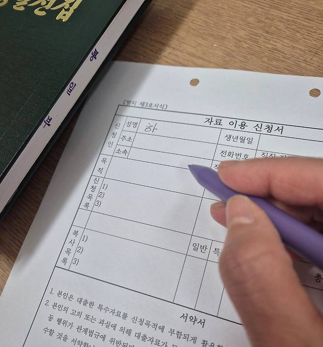 '특수자료' 복사 때 작성해야 하는 서류    (서울=연합뉴스) 하채림 기자 = 통일부 북한자료센터에서 7일 이용자가 '특수자료'인 '김정일 전집'을 복사하기 위해 '자료 이용 신청서'를 작성하고 있다.
