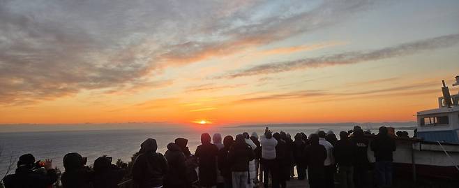 새해 첫날 포항시 북구 흥해읍 오도리 사방기념공원 묵은봉 정상에서 해맞이 하는 사람들. ‘갯마을 차차차’ 드라마 촬영지로 극 중 홍반장의 배가 놓여있다.