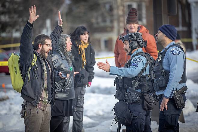 7일(현지 시각) 미국 미니애폴리스에서 발생한 총격 사건 현장에서 시위대가 경찰관들과 대치하고 있다./AP 연합뉴스