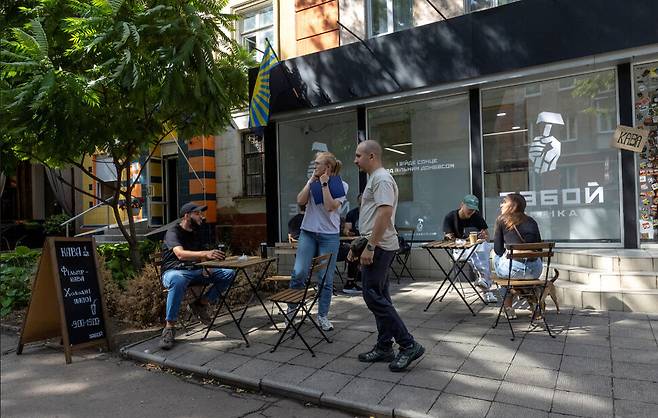 지난해 9월10일 우크라이나 크라마토르스크. 거리의 카페에서 차를 마시던 한 여인이 인근 주변에서 비행하던 드론의 폭발음에 귀를 막고 있다. 로이터 연합뉴스