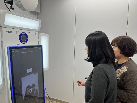 청주시 청원구청을 방문한 민원인들이 행복사진관에서 포토키오스크를 이용하고 있다. [사진=청원구청]