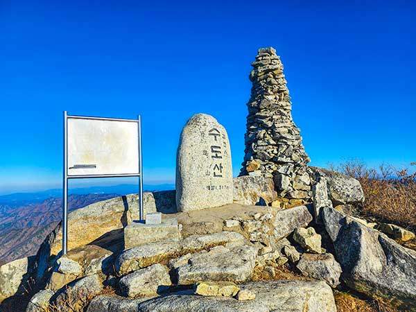수도산 정상. 일년 반 동안 200개의 산을올랐다는 산꾼이 김천 쪽 산들을 바라보고 있다. 초겨울 날씨에 그의 셔츠는 완전히 땀에젖었다. 경북 김천과 경남 거창의 경계인데, 거창 표식은 없다.