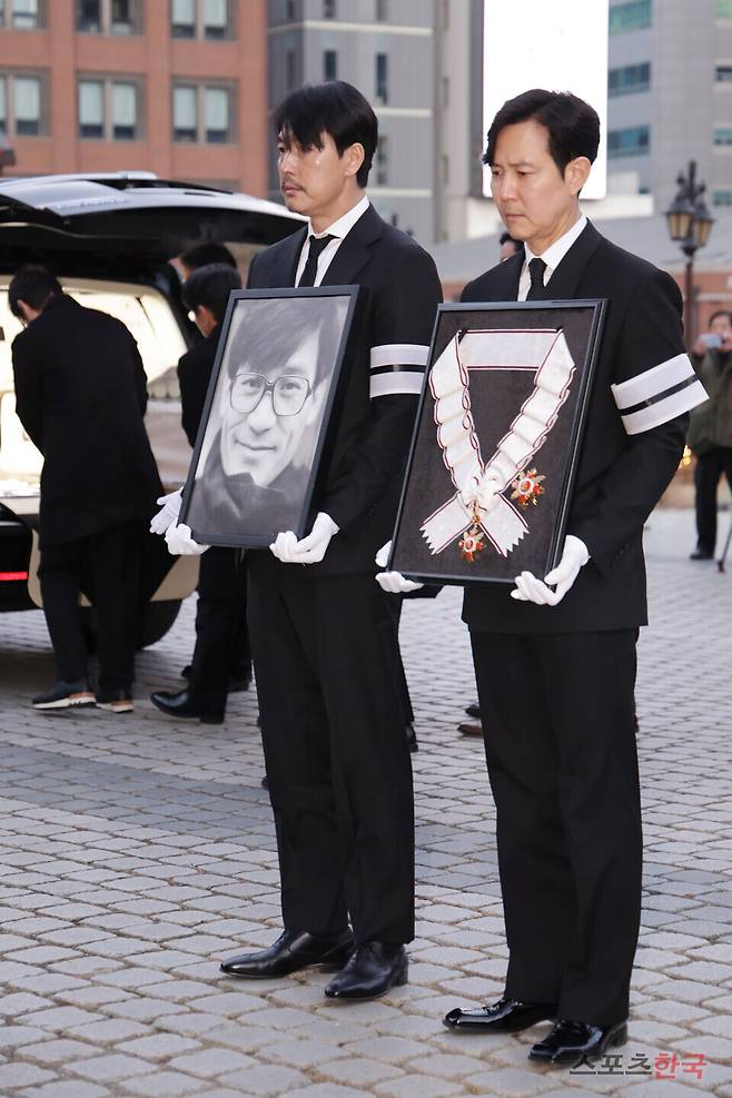 배우 故 안성기의 영결식이 9일 오전 서울 중구 명동성당에서 엄수된 가운데 정우성이 영정 사진을 들고, 이정재가 훈장을 봉헌하고 있다. 26.1.9 ⓒ이혜영 기자 lhy@hankooki.com
